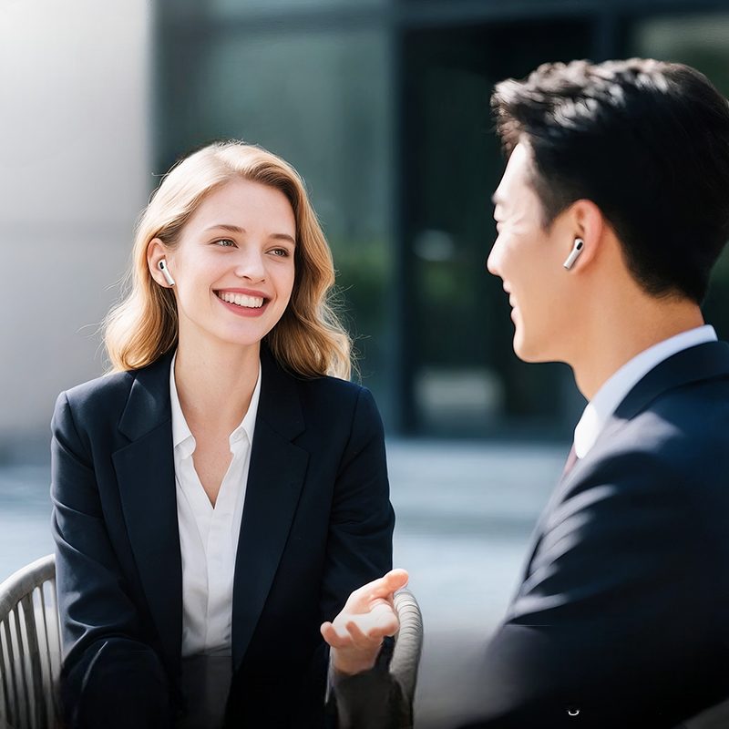 Two professionals in business attire engaged in a conversation outdoors.