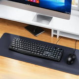 Black keyboard and mouse on a desk with a computer monitor in the background