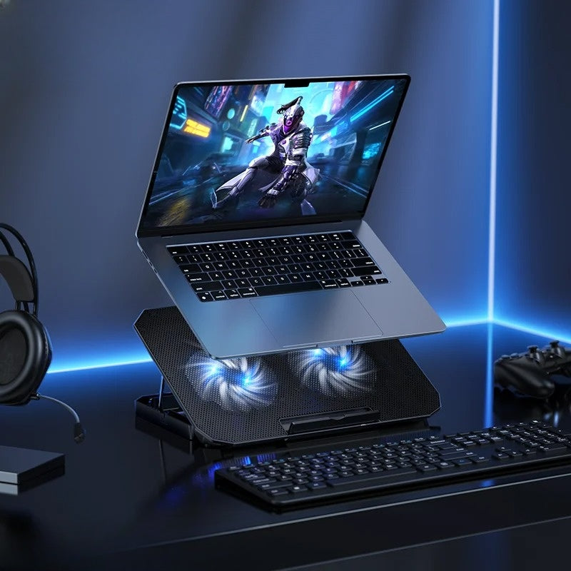 Laptop on a cooling stand with glowing fans on a desk setup