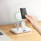 Hand holding a card above a small round mirror on a stand with a laptop in the background.