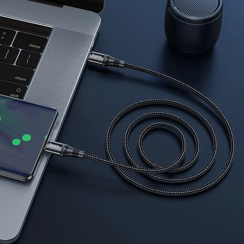 Laptop, smartphone, and black braided cable on a dark surface